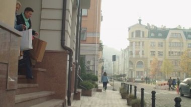Elinde bir sürü kesekâğıdı olan iki kadın alıcı dışarıda dolaşıyor.
