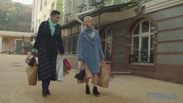 Las mujeres de mediana edad de compras, disfrutando de pasatiempo en la jubilación al aire libre — Vídeos de Stock