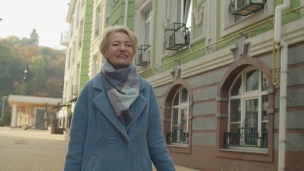 Veselý starý žena házení papírové tašky přes rameno venku — Stock video