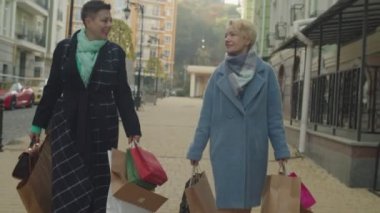 Yaşlı kadınlar bir sürü kese kâğıdı taşıyor, dışarıda gezmekten zevk alıyorlar.