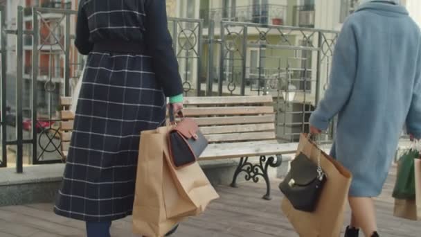 Äldre kvinnliga köpare med många papperspåsar gnugga ömma fötter utomhus — Stockvideo