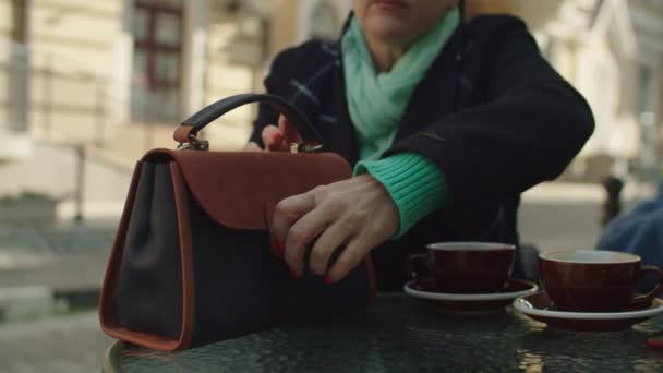 Zwei reife erwachsene Frauen, die sich schminken und draußen am Cafétisch sitzen — Stockvideo