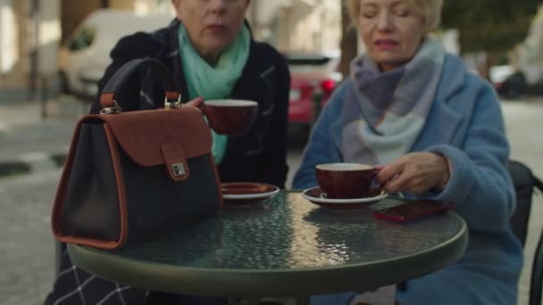 Kamera dreht sich um Coffeeshop-Tisch mit Tasche und Tassen mit Getränken — Stockvideo