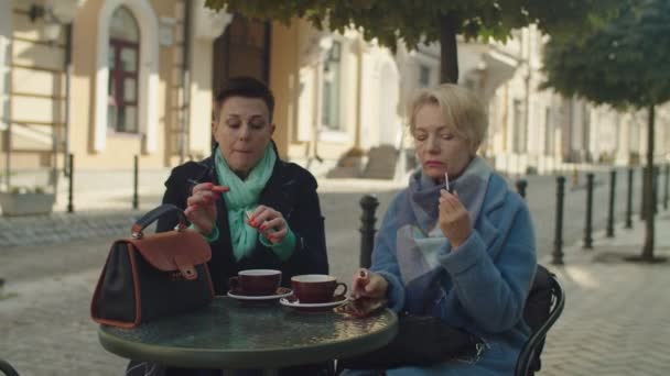 中年の女性は、口紅を屋外に置く、スマートアップ — ストック動画