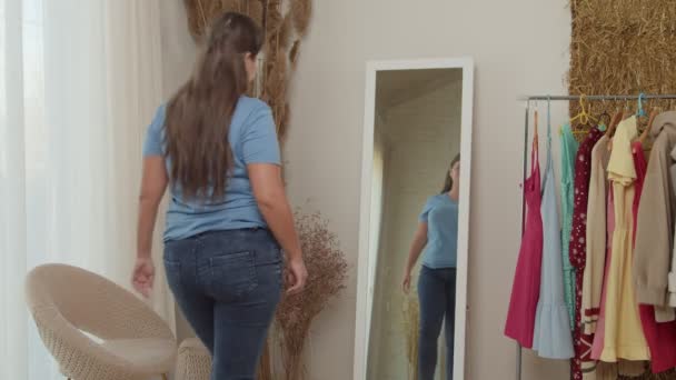 Plump lady looking on reflection, checking fat fold on belly indoors — Stock Video