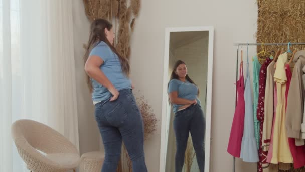 Mollige vrouw het aantrekken van jeans, springen gelukkig, uiten vreugde binnen — Stockvideo