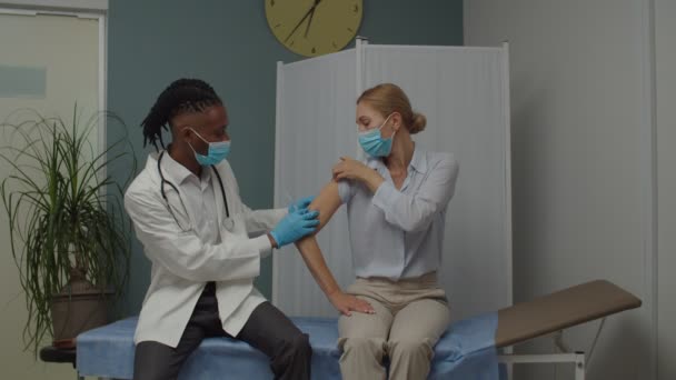 Medico o infermiere maschio che effettua l'iniezione di vaccino al paziente in ambienti chiusi — Video Stock
