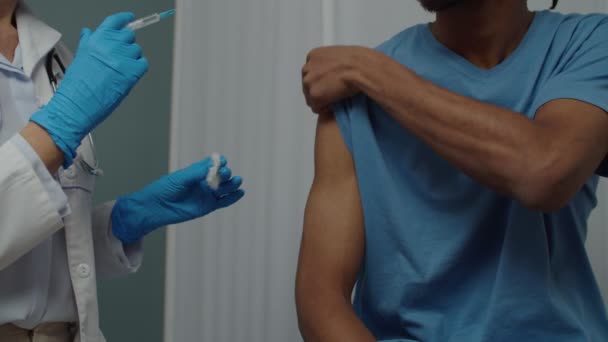 Parte central do médico enfermeiro que administra a injeção da vacina ao doente no interior — Vídeo de Stock