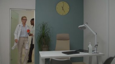 Kadın doktor ve stajyer doktor. Ofise kahve getiriyorlar.