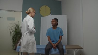 Doktor içeride dijital termometreyle vücut ısısını ölçüyor.