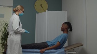 Kadın doktor, elleri avuçta, hasta erkek hasta, içeride.