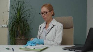 Kadın doktor ameliyata hazırlanıyor, içeride lateks eldiven takıyor.