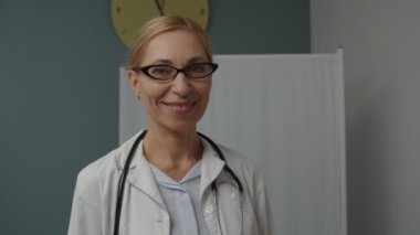 İçerde gözlüklü neşeli kadın doktorun portresi.