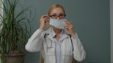 Kadın doktor içeride koronavirüsü korumak için yüz maskesi takıyor.