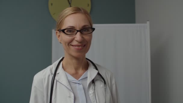 Πορτρέτο της χαρούμενης γυναίκας γιατρός σε γυαλιά μέσα στο σπίτι — Αρχείο Βίντεο