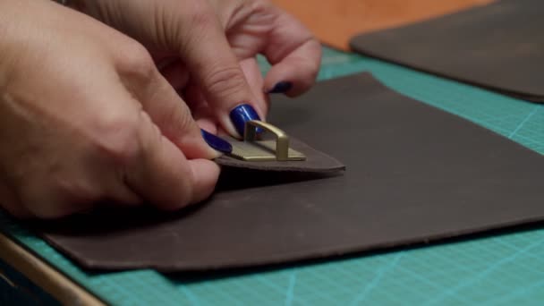 Dámské ruce lepení kovové detaily přichytit na originální kus kůže uvnitř — Stock video