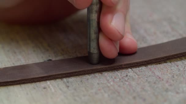 パンチを適用する労働者の手は、革の詳細室内に穴を作る — ストック動画