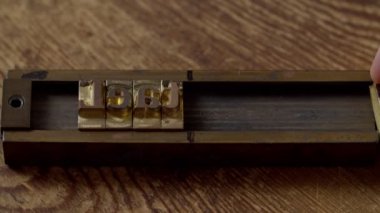 Metal sembolleri blok tutucusuna yerleştiren işçilerin yakın plan görüntüleri