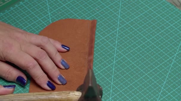 Pracovník ruce klepání s kladivem přilepený okraj koženého kusu uvnitř — Stock video