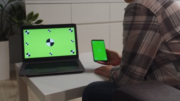 Сторона руху камери, жінка тримає телефон з хроматичним зеленим екраном — стокове відео