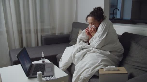 Mujer enferma tomando consulta médica a través de videocall en el ordenador portátil en el interior — Vídeo de stock
