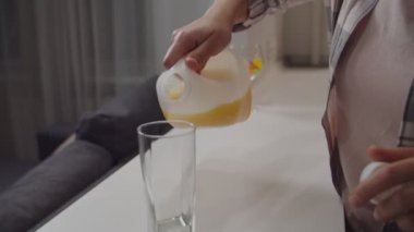 Tanımlanamayan bir kadın plastik şişeden meyve suyu dolduruyor.