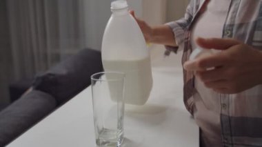 Tanımlanamayan bir kadın plastik şişeden süt dolduruyor.