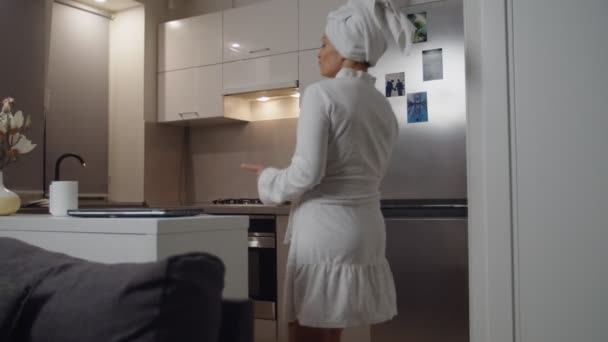 Woman in good spirits dancing, drinking beverage after shower at home — 图库视频影像