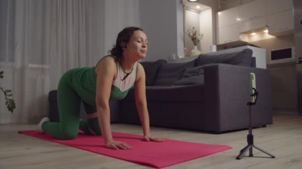 Treinador feminino segurando vídeo tutorial on-line, mostrando Cat Vaca Exercício — Vídeo de Stock