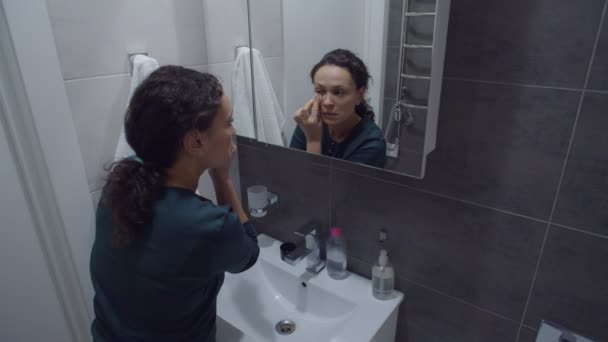 Zwarte vrouw schoonmaken gezicht met cosmetische katoenen pad, verwijderen van make-up — Stockvideo