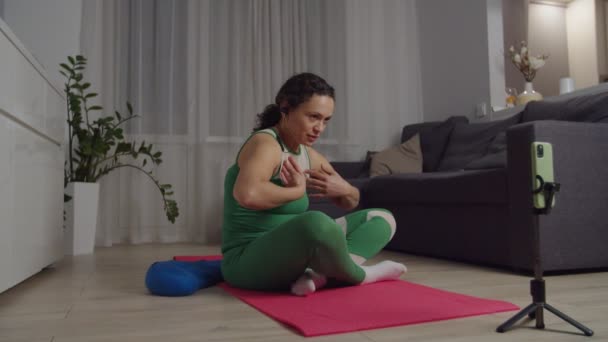 Entrenadora femenina retransmitiendo video tutorial, mostrando buena postura corporal — Vídeos de Stock
