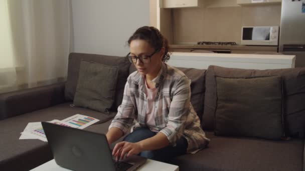 Gözlüklü, evde çalışan yetişkin bir kadının hareketli fotoğrafı. — Stok video