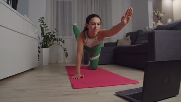 Slim woman developing good balance, posture, using laptop at home — ストック動画