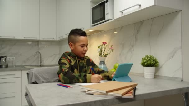 Preteen iskolás csinál házi feladatot digitális tablet Internet beltéri — Stock videók