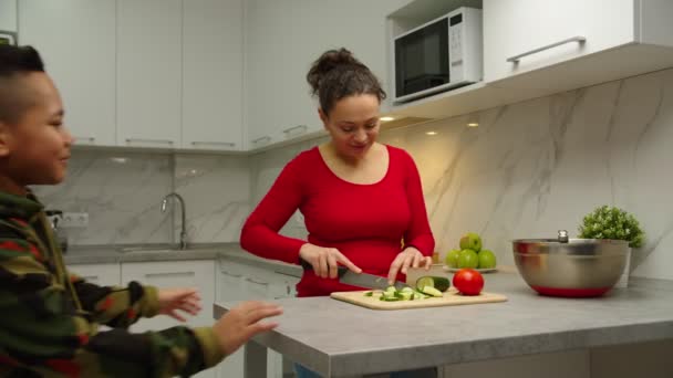 Mamá dando tazón batidor a hijo, él comienza a azotar ingredientes en el interior — Vídeo de stock