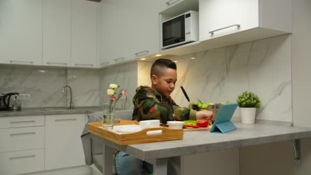 Adorable chico siguiendo video para hacer el desayuno a mamá en casa — Vídeos de Stock