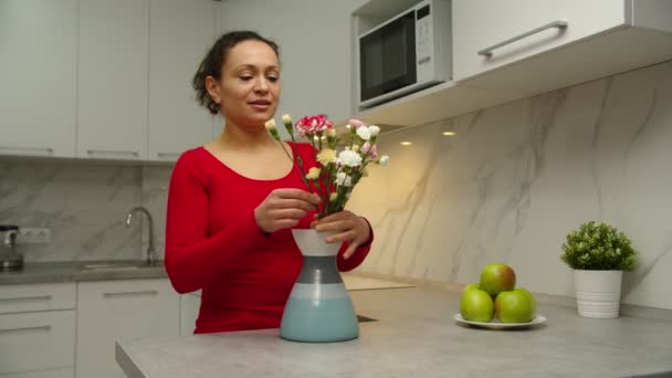 Mujer negra poniendo ramo en jarrón, arreglando flores en el interior — Vídeos de Stock