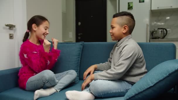 Multiétnico chico y chica dando choca esos cinco, riendo juntos en casa — Vídeo de stock