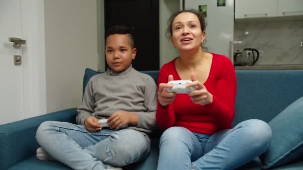 Frente tiro em movimento de mãe e filho jogando videogame em casa — Vídeo de Stock