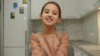 Neşeli, sevimli, gülümseyen kız evde olumlu duygular ifade ediyor.