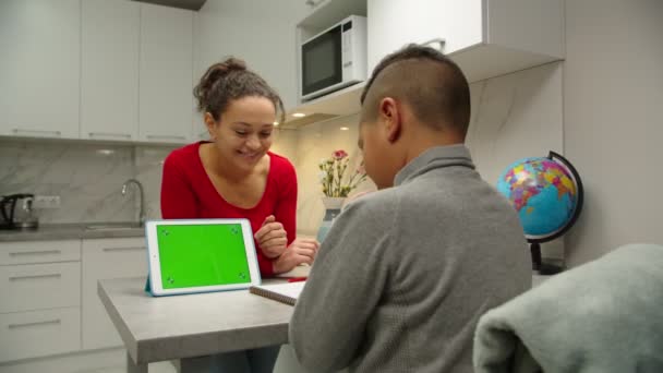 Mamá usando la tableta con la pantalla verde de la llave del croma para la educación en casa — Vídeos de Stock