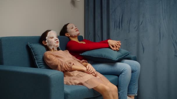 Preteen Mädchen und Mutter Anwendung kosmetischer Gesichtsmaske entspannen zu Hause — Stockvideo