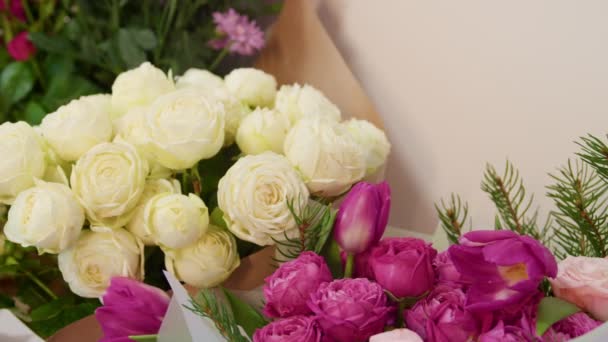 Concentre-se em um monte de rosas com poucas tulipas e ramos de abeto na loja de flores — Vídeo de Stock