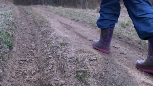 Section basse de l'enfant avec bâton grimpant au sommet de la colline en plein air — Video