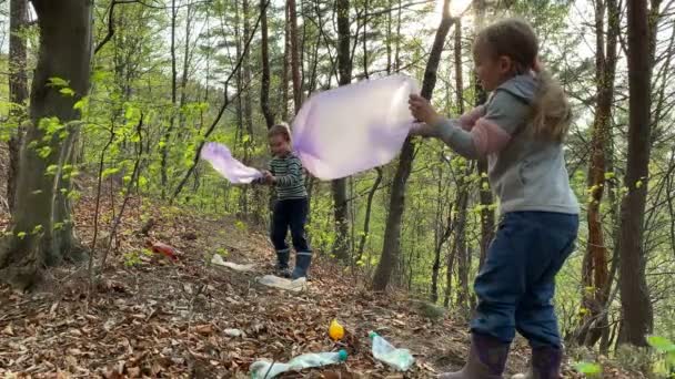 Crianças segurando sacos de lixo, preparando-se para coletar plástico ao ar livre — Vídeo de Stock
