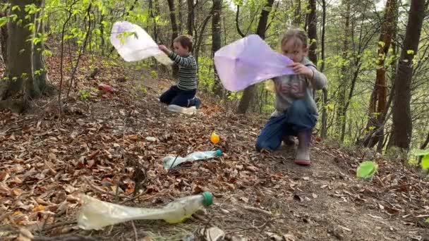 Dos pequeños voluntarios limpiando el bosque juntos — Vídeo de stock