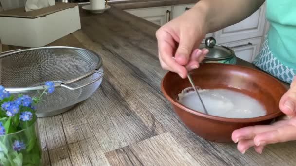 White female hands stirring yeast in water, preparing leaven indoors — Stockvideo