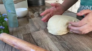 İçerideki ahşap atölyede hamur yoğuran kadın.