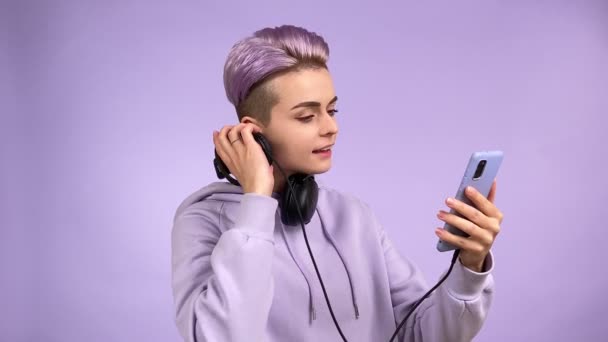 스튜디오는 유행하는 스마트폰을 사용하여 플레이 리스트에서 노래를 선택하고 자외선 헤드폰을 — 비디오