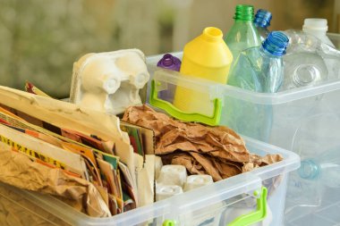 Konteynırlar farklı plastik şişeler ve bulanık arka plandaki atık kağıtları doldurdu. Naylon ayıklama, geri dönüşüm için kâğıt toplama, yükseltme, indirme. Çevre koruma. Atık azaltılıyor